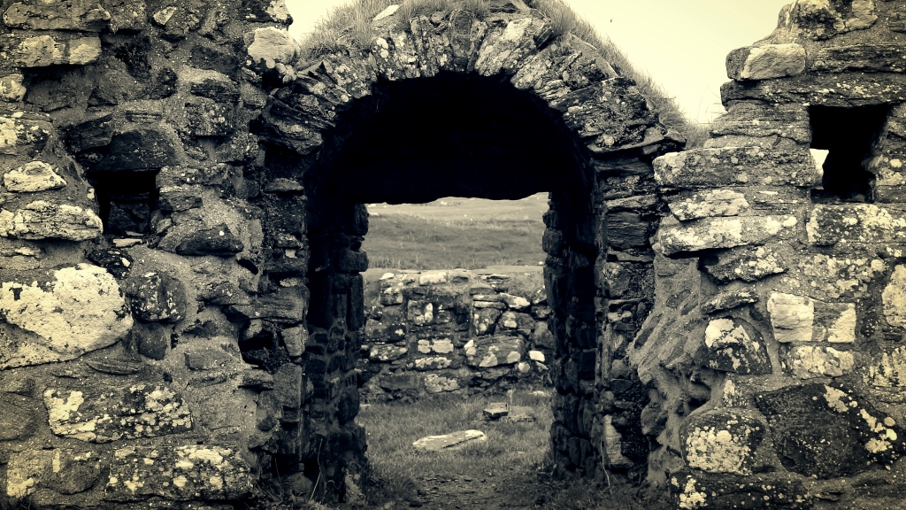 black and white photo looking through a ruined doorway in an abandoned blackhouse on South Uist. 
